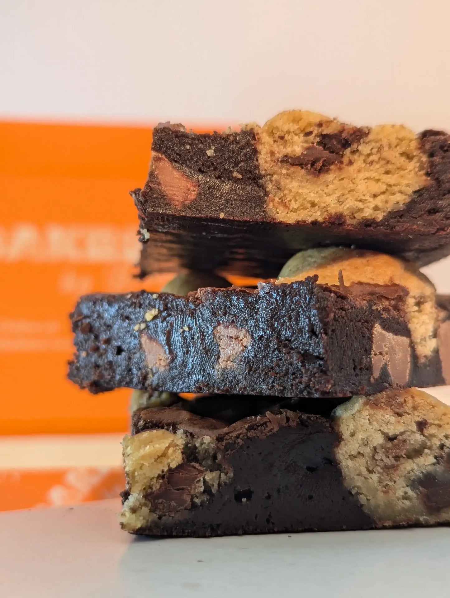 Stack of cookie dough brownies orange box in background